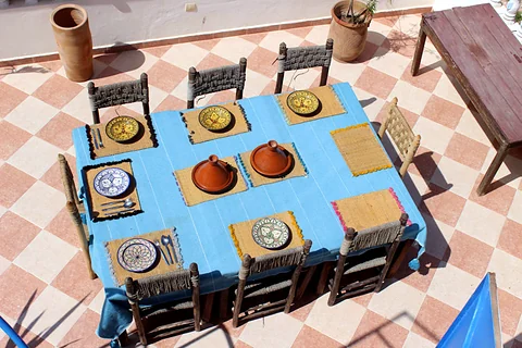 Rooftop table set with Moroccan plates and tagines
