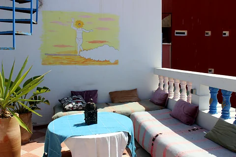 Rooftop chill-out lounge with cushions and a surf mural
