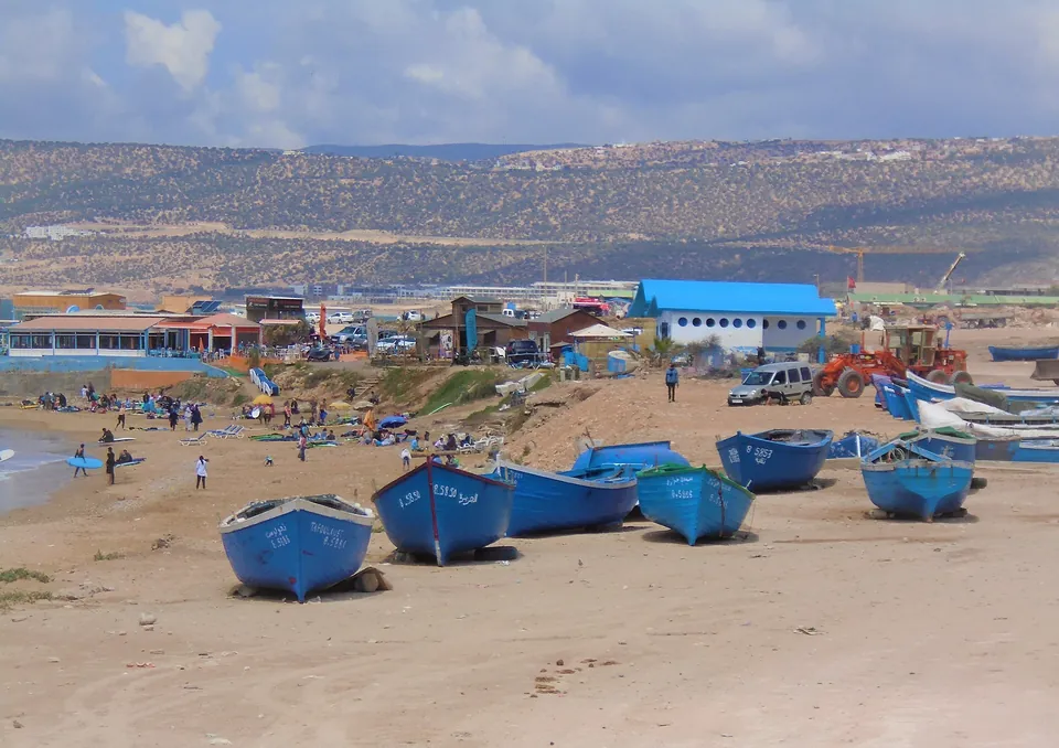 Devil's Rock beach in Aourir with blue fishing boats