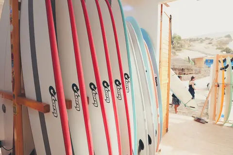 Rack of soft-top surfboards